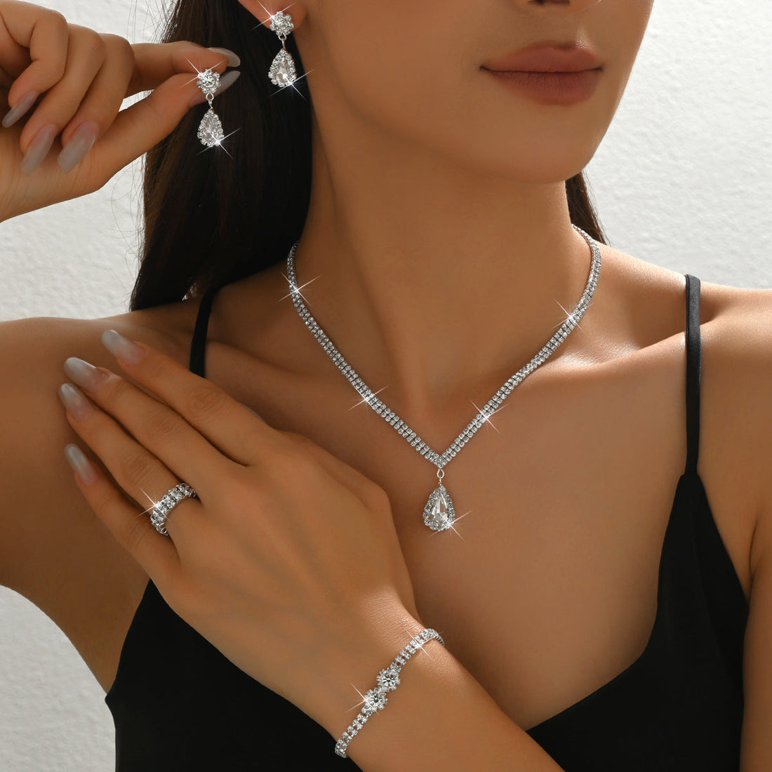 4-Piece Bridal Crystal Jewelry Set featuring teardrop necklace, dangle earrings, crystal bracelet, and adjustable ring